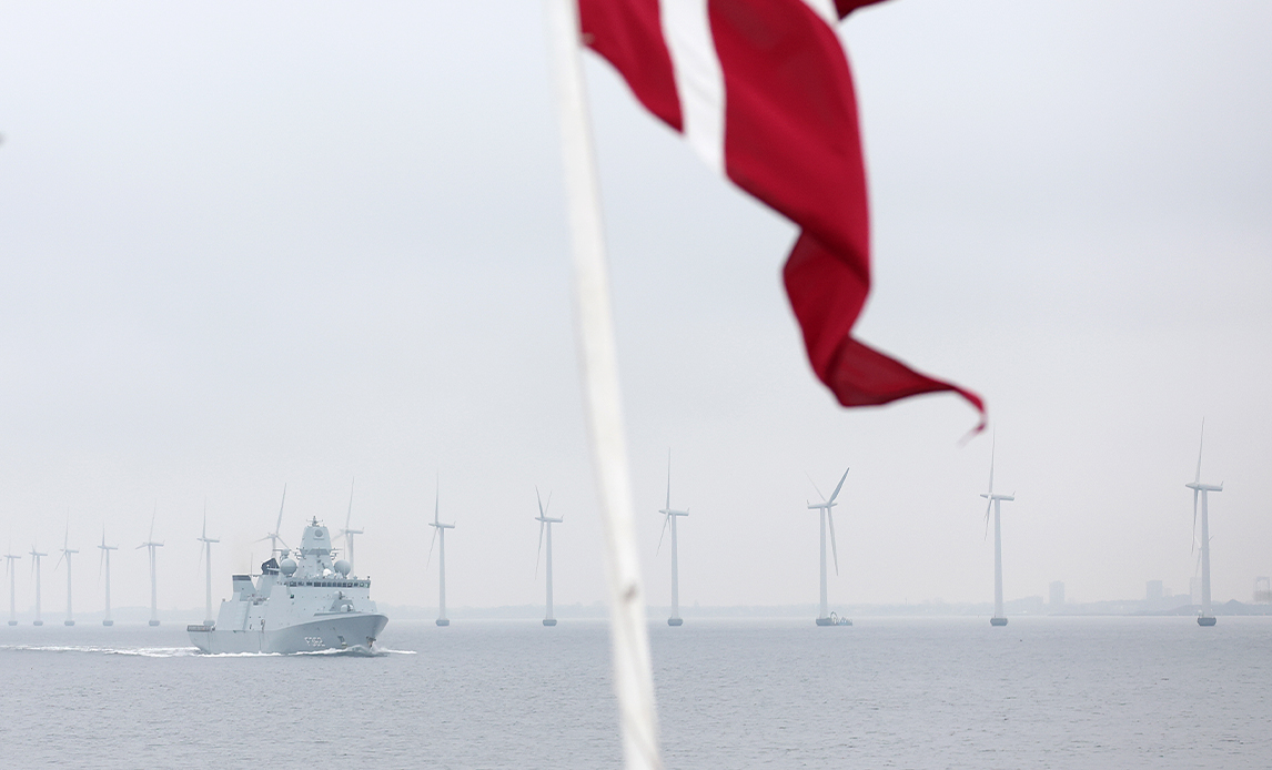 Skib patruljerer foran vindmøller